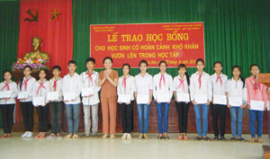 Đồng chí Nguyễn Thị Lợi, Phó Chủ tịch Hội khuyến học tỉnh trao học bổng cho các em học sinh nghèo vượt khó huyện Lạc Sơn.